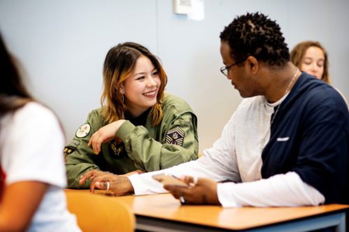 Voltijd studenten die in groepsverband samenwerken in een klaslokaal.